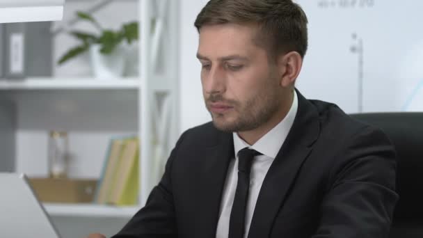 Serious male manager working on laptop suddenly feeling sharp ache in shoulder - Footage, Video
