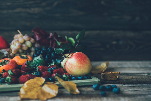 Fresh farmers market organic fruits. Vintage wooden tray and fruits on wooden table. Food background. Healthy food. Toned image. - Photo, Image