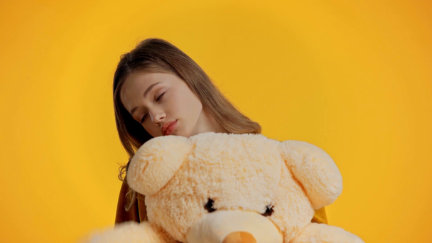 trauriger Teenager hält Teddybär isoliert auf gelb - Filmmaterial, Video