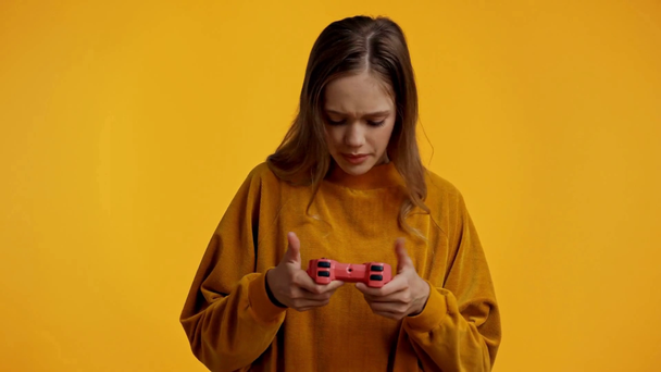KYIV, UKRAINE - OCTOBER 18, 2019: teenager playing video game isolated on yellow - Felvétel, videó