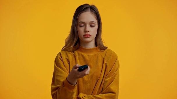 tiener met behulp van afstandsbediening geïsoleerd op geel - Video
