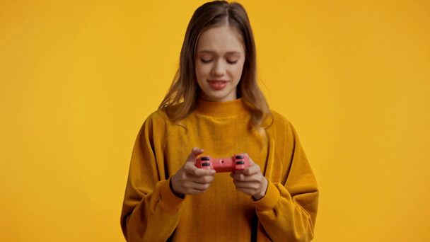 KYIV, UKRAINE - OCTOBER 18, 2019: teenager playing video game isolated on yellow - Metraje, vídeo
