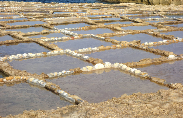 Casseroles ou salines à Xwejni, Zebbug, Gozo, Malte, lieu de longue date pour la production de sel, avec des casseroles en motifs géométriques au bord de l'océan
 - Photo, image