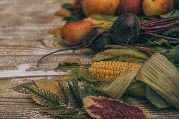 黄色い葉、赤いリンゴとカボチャと秋の背景。コピースペースを持つ熟成木材上の秋の収穫のフレーム。季節のオファーのためのモックアップ。トーン画像、コピースペース. - 写真・画像