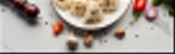 bovenaanzicht van heerlijke khinkali in de buurt van groenten en specerijen op marmeren tafel, panoramisch schot - Foto, afbeelding