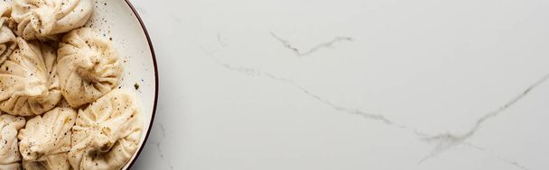 vista superior de khinkali delicioso fresco na mesa de mármore, tiro panorâmico
 - Foto, Imagem