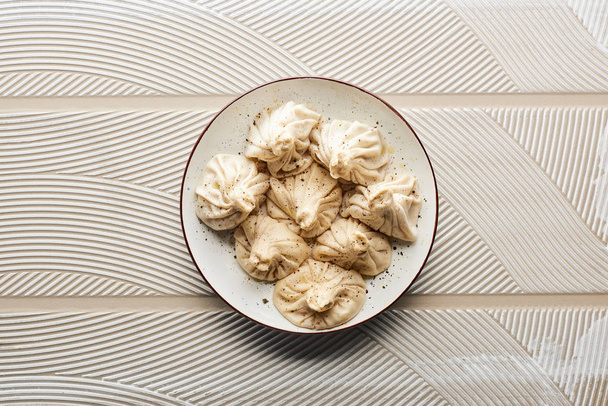 top view of fresh delicious khinkali on textured beige background - Valokuva, kuva