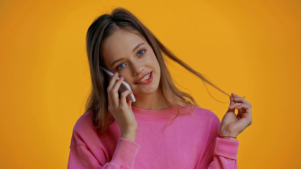 smiling teenager talking on smartphone isolated on yellow - Záběry, video