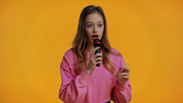 έφηβος τραγουδούν με μικρόφωνο απομονώνονται σε κίτρινο  - Πλάνα, βίντεο