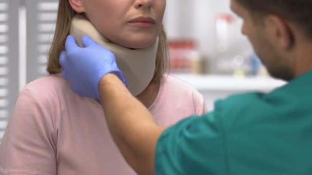 Traumatologist examination of female patient with foam cervical collar, injury - Záběry, video