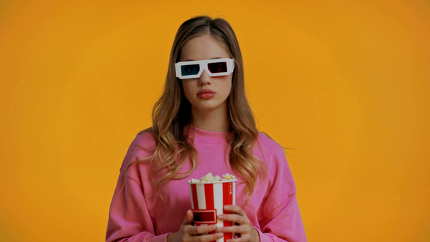 tiener kijken film en het eten van popcorn geïsoleerd op geel - Video