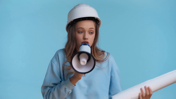 usmívající se teenager mluví s reproduktorem izolované na modré - Záběry, video
