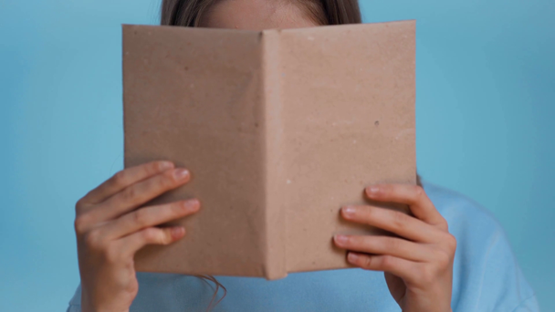 ιερό βιβλίο ανάγνωσης εφήβων απομονωμένο στο μπλε - Πλάνα, βίντεο