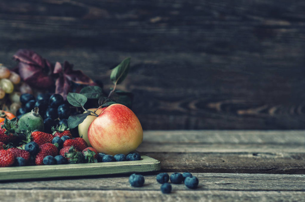 Fresh farmers market organic fruits. Vintage wooden tray and fruits on wooden table. Food background. Healthy food. Toned image. - Photo, image