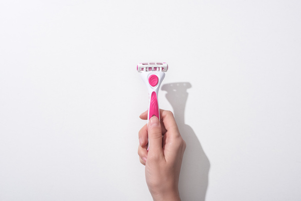 cropped view of woman holding female pink razor on white background - Photo, Image