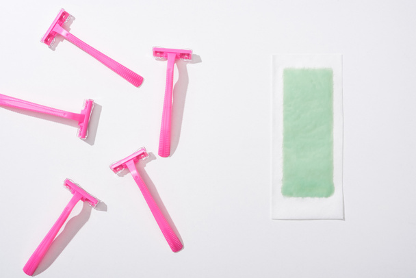 top view of female pink razors and depilation stripe on white background - Photo, Image