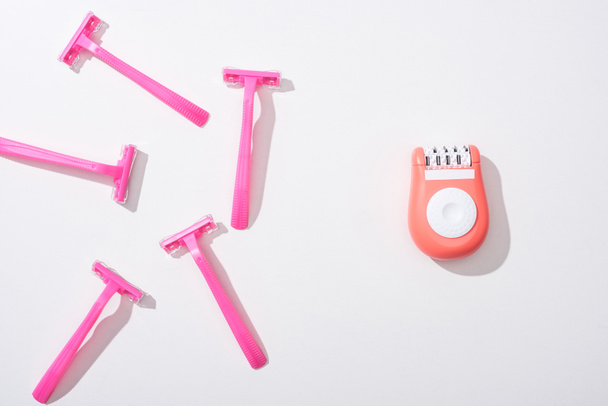 top view of female pink razors and epilator on white background - 写真・画像