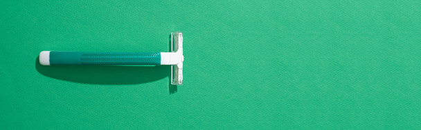 top view of green disposable razor on green background, panoramic shot - Фото, зображення