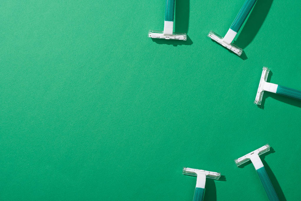 top view of green disposable razors on green background - Fotó, kép