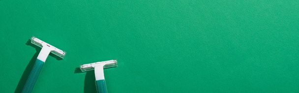top view of green disposable razors on green background, panoramic shot - Fotó, kép