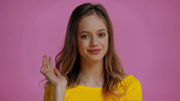 glimlachende tiener groet geïsoleerd op roze - Video