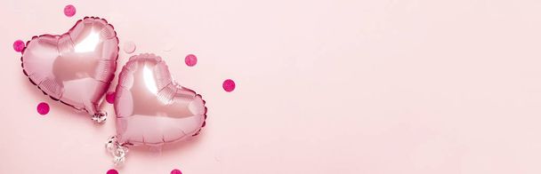Two pink air balloons in the shape of a heart on a pink background. Concept Valentine's Day, Wedding Decoration. Foil balls. Banner. Flat lay, top view - Fotoğraf, Görsel