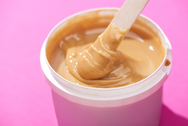 close up view of depilation wax in container with stick on pink background - Photo, Image