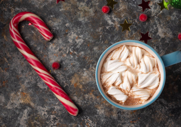 Kerst en Nieuwjaar gezellige vakantie compositie met mokken met cacao of chocolade, snoep, rode bes op de donkere achtergrond. Vlakke lay, bovenaanzicht - Foto, afbeelding