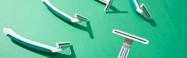selective focus of disposable razors on green background, panoramic shot - Foto, immagini