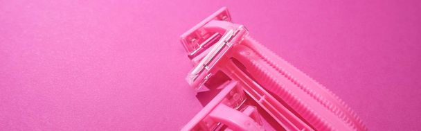 maquinillas de afeitar femeninas desechables sobre fondo rosa con espacio para copiar, plano panorámico
 - Foto, Imagen