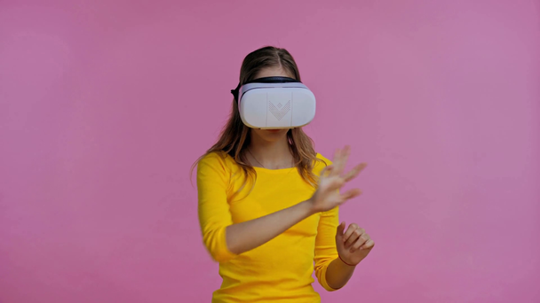 teenager in virtual reality headset pointing with finger isolated on pink - Video, Çekim