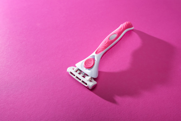 feminine razor on pink background with copy space - Foto, imagen