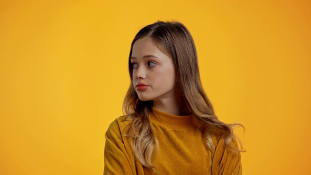 teenager pózování a pohled na kameru izolované na žluté - Záběry, video