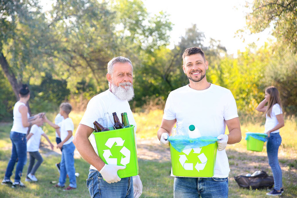 Men with gathered garbage outdoors. Concept of recycling - Foto, afbeelding