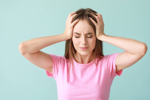 Mladá žena trpí bolest hlavy na barvu pozadí - Fotografie, Obrázek