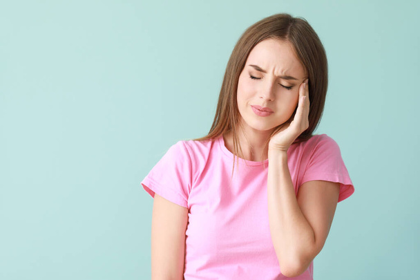 Genç kadın renk arka plan üzerinde baş ağrısı muzdarip - Fotoğraf, Görsel