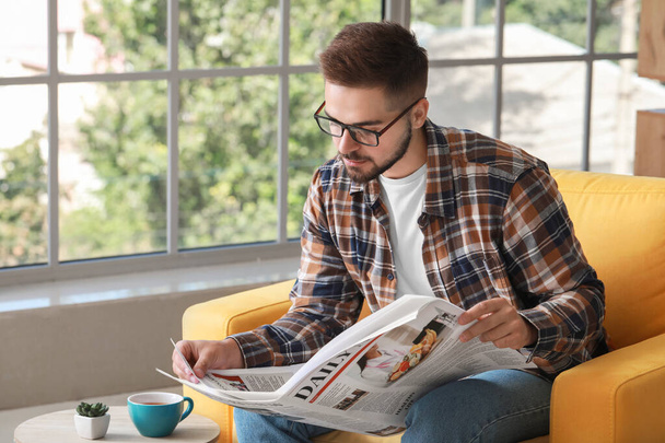 Bell'uomo che legge il giornale a casa
 - Foto, immagini