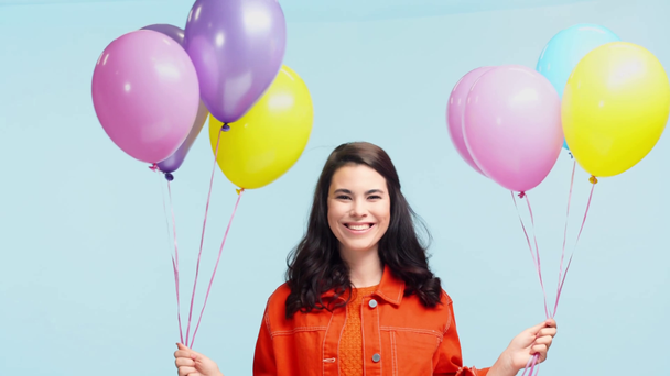 χαμογελαστό κορίτσι με μπαλόνια κόμμα απομονώνονται σε μπλε - Πλάνα, βίντεο