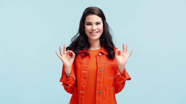 happy girl showing ok signs isolated on blue - Video