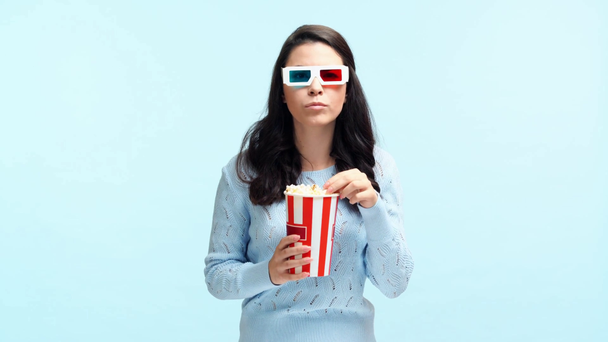 concentrato ragazza in 3d bicchieri mangiare popcorn isolato su blu
 - Filmati, video
