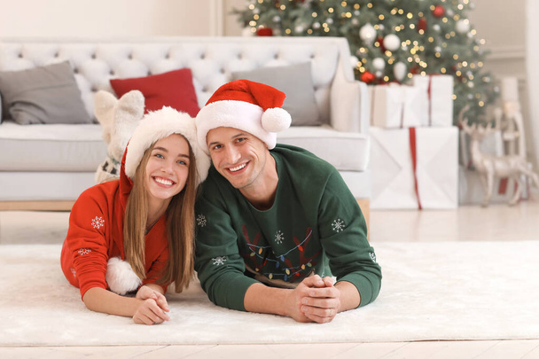 Happy young couple on Christmas eve at home - Фото, зображення