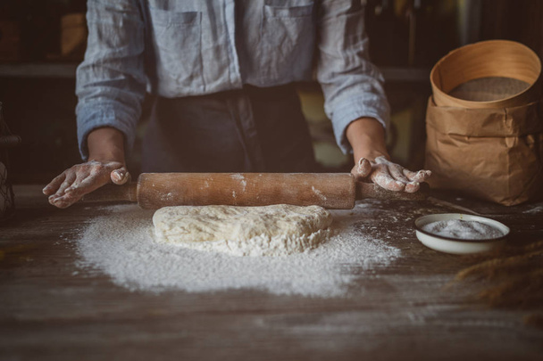 Hands make dough. Recipe homemade bread. Female hands making dough for pizza with a rolling pin. - Zdjęcie, obraz