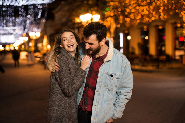Onnellinen nuori pari kävelee kauniissa kaupungissa illalla
 - Valokuva, kuva