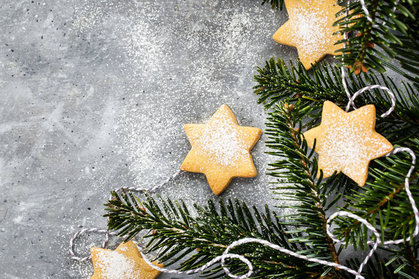 Chrismtas cookie stars and fir tree branches on gray background, - Zdjęcie, obraz
