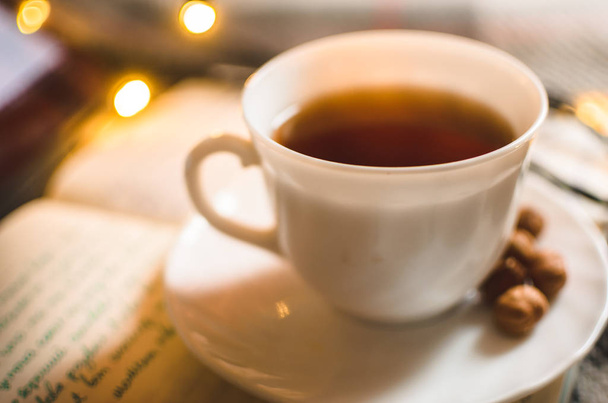 Hot black tea in an irony and warm atmosphere with a garland, Christmas atmosphere, morning lighting - Photo, Image