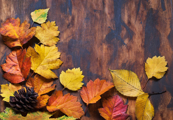 Gevallen bladeren op houten achtergrond, bovenaanzicht, kopieerruimte - Foto, afbeelding