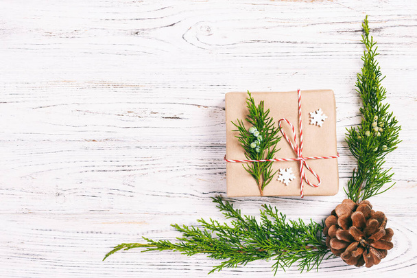 Vánoční kompozice pozadí. Vánoční dárek s borovicovými kužely a jedlovými větvemi na dřevěném pozadí. Byt ležel, horní pohled, kopírovací prostor. Izolované - Fotografie, Obrázek