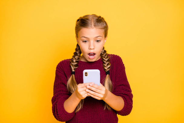 Close-up portrait of her she nice attractive lovely girlish stunned pre-teen girl reading news blog post smm reaction feednews isolated on bright vivid shine vibrant yellow color background - Foto, Imagem