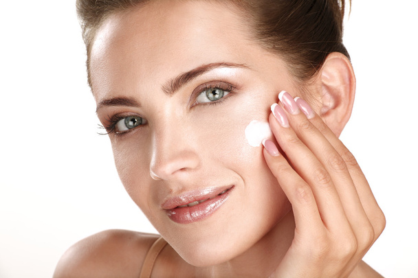 beautiful model applying cosmetic cream treatmen on her face - Fotografie, Obrázek