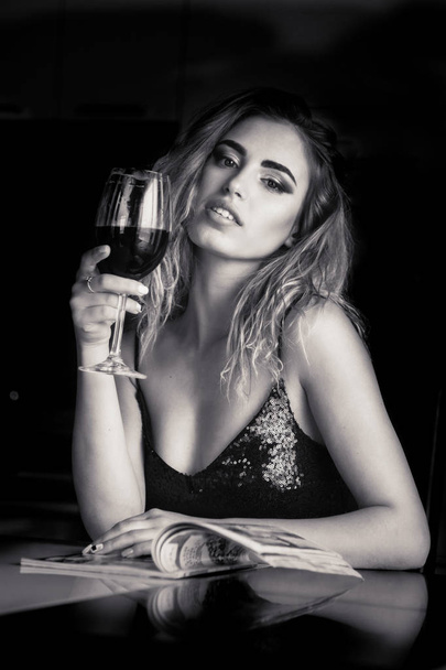 ελκυστική νεαρή γυναίκα με ένα ποτήρι κρασί στο σπίτι - Φωτογραφία, εικόνα